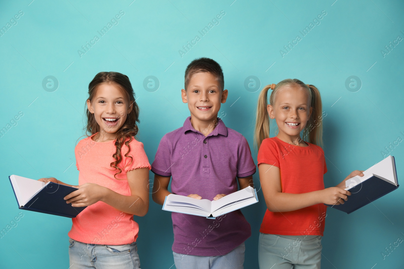 Photo of Portrait of little children reading books on turquoise background