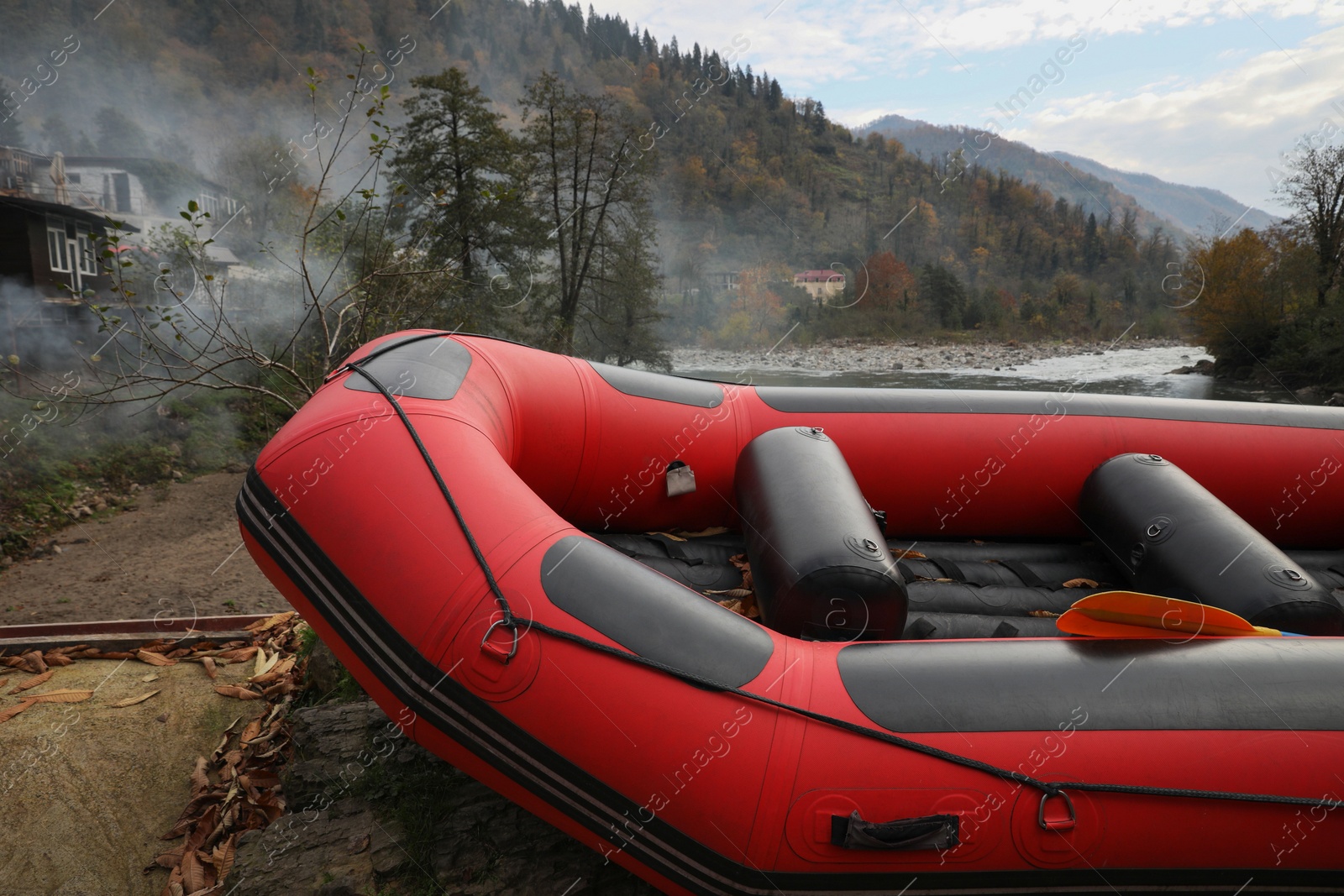 Photo of Inflatable rubber fishing boat near river in mountains