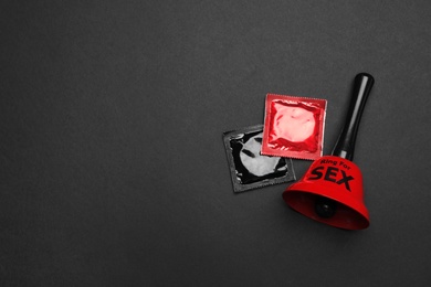 Sex bell and condoms on black background, top view. Space for text