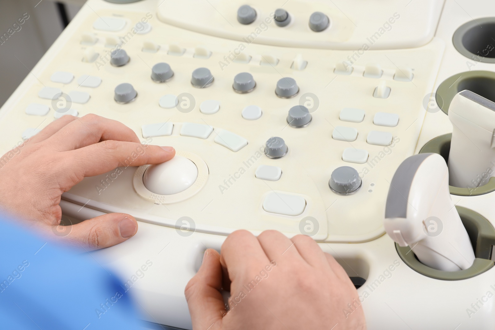 Photo of Sonographer operating modern ultrasound machine in clinic, closeup