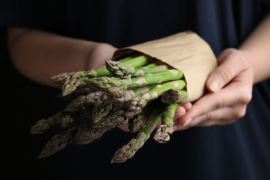 Photo of Woman with fresh raw asparagus, closeup view