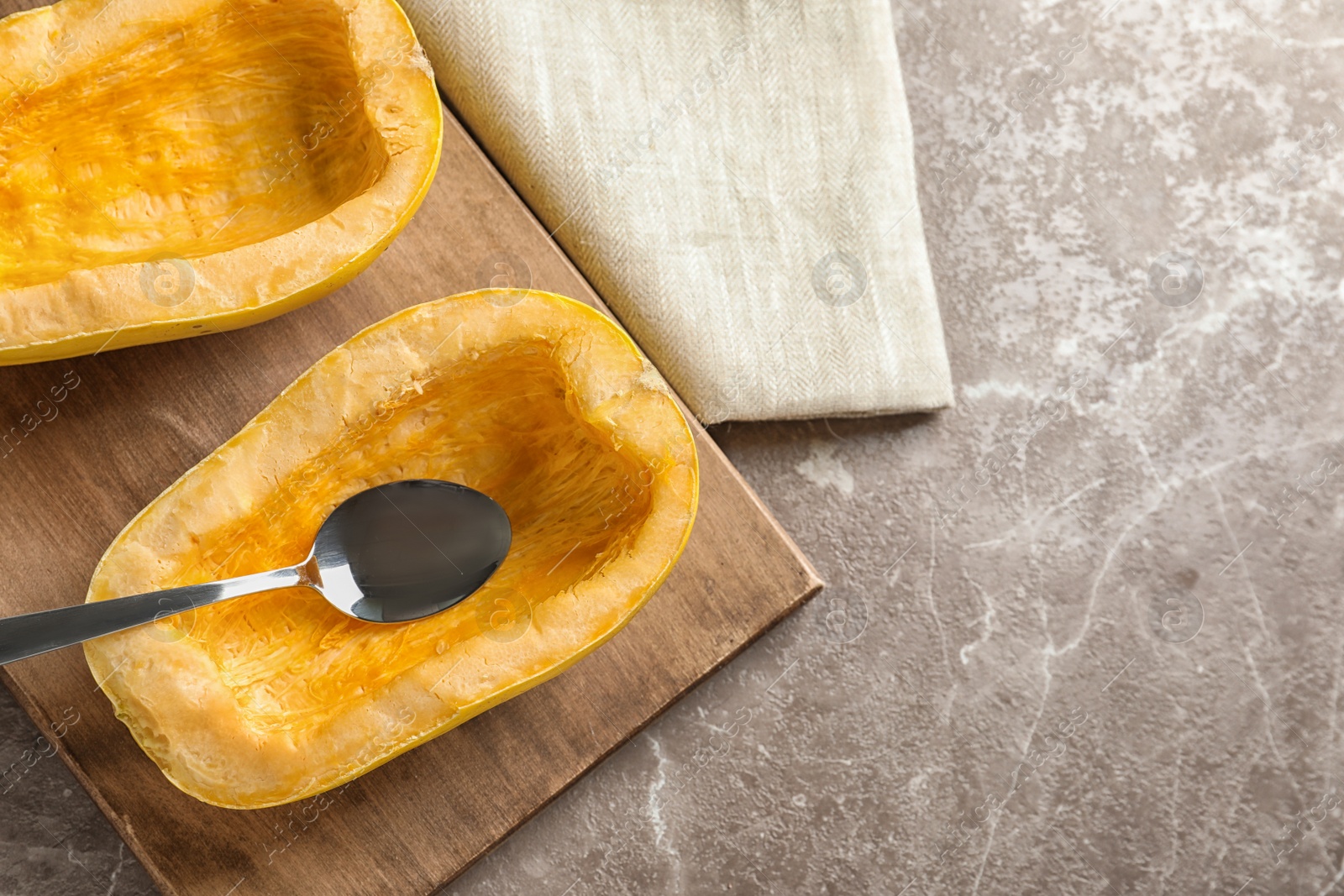 Photo of Flat lay composition with cut spaghetti squash and spoon on gray background. Space for text