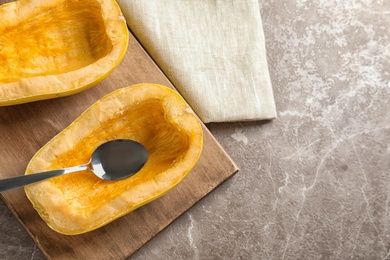 Flat lay composition with cut spaghetti squash and spoon on gray background. Space for text