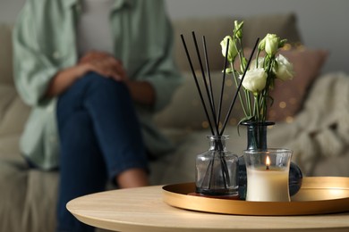 Home decor on wooden table and woman sitting in living room