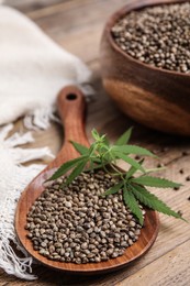 Organic hemp seeds and leaves on wooden table