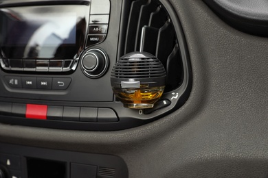 Stylish air freshener hanging near car ventilation