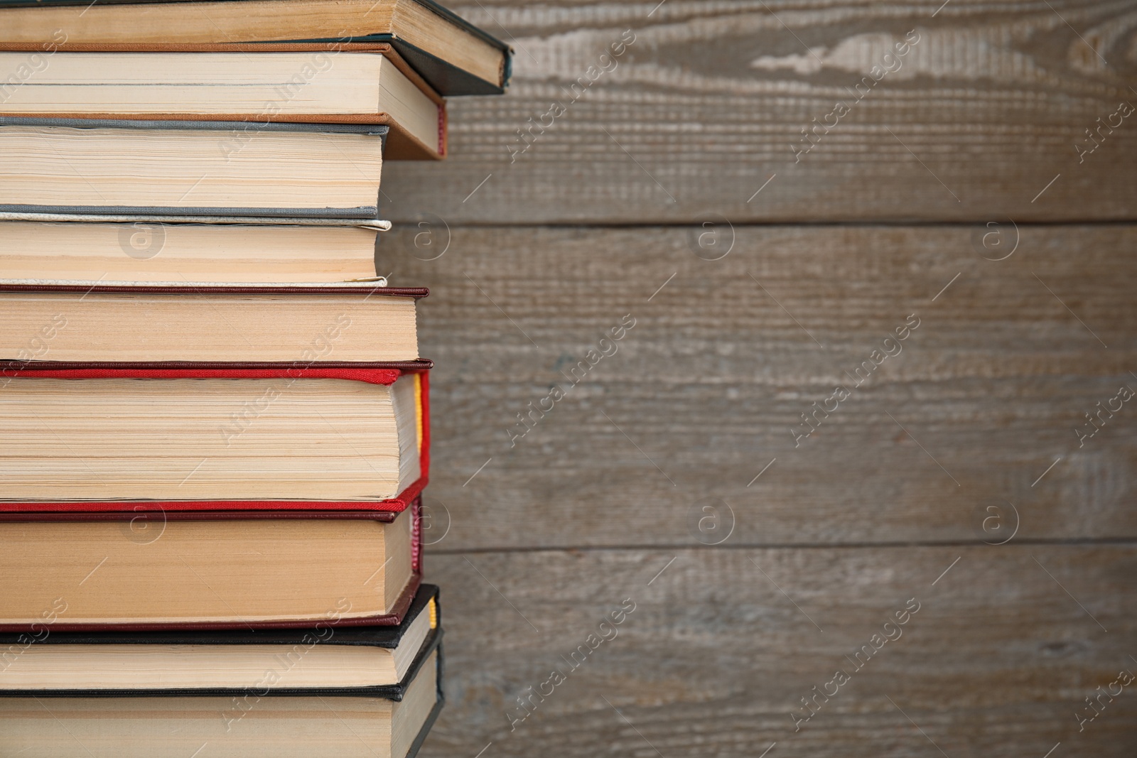 Photo of Stack of hardcover books on wooden background. Space for text