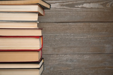 Photo of Stack of hardcover books on wooden background. Space for text