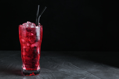 Photo of Tasty cocktail with ice cubes on grey table. Space for text