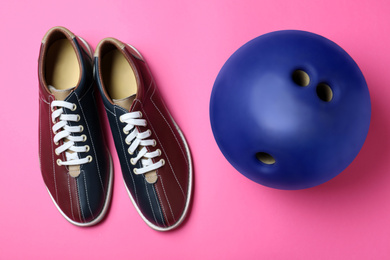 Photo of Bowling ball and shoes on pink background, flat lay