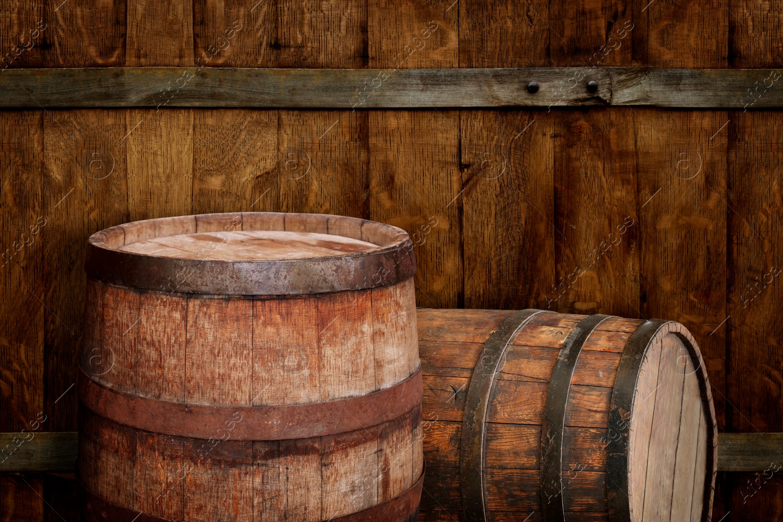 Image of Two wooden barrels near old textured wall