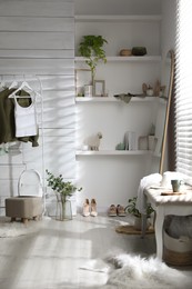 Photo of Rack with different stylish clothes, shoes and decorative elements in dressing room. Interior design