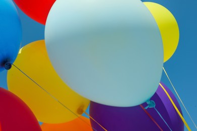 Photo of Bright colorful balloons with ribbons, closeup view