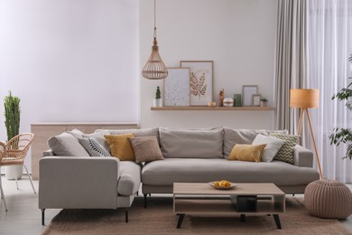 Photo of Stylish living room interior with comfortable grey sofa and coffee table
