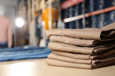 Photo of Stack of brown jeans on display in shop
