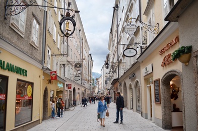 Photo of SALZBURG, AUSTRIA - JUNE 22, 2018: Row of small stores with signboards on city street