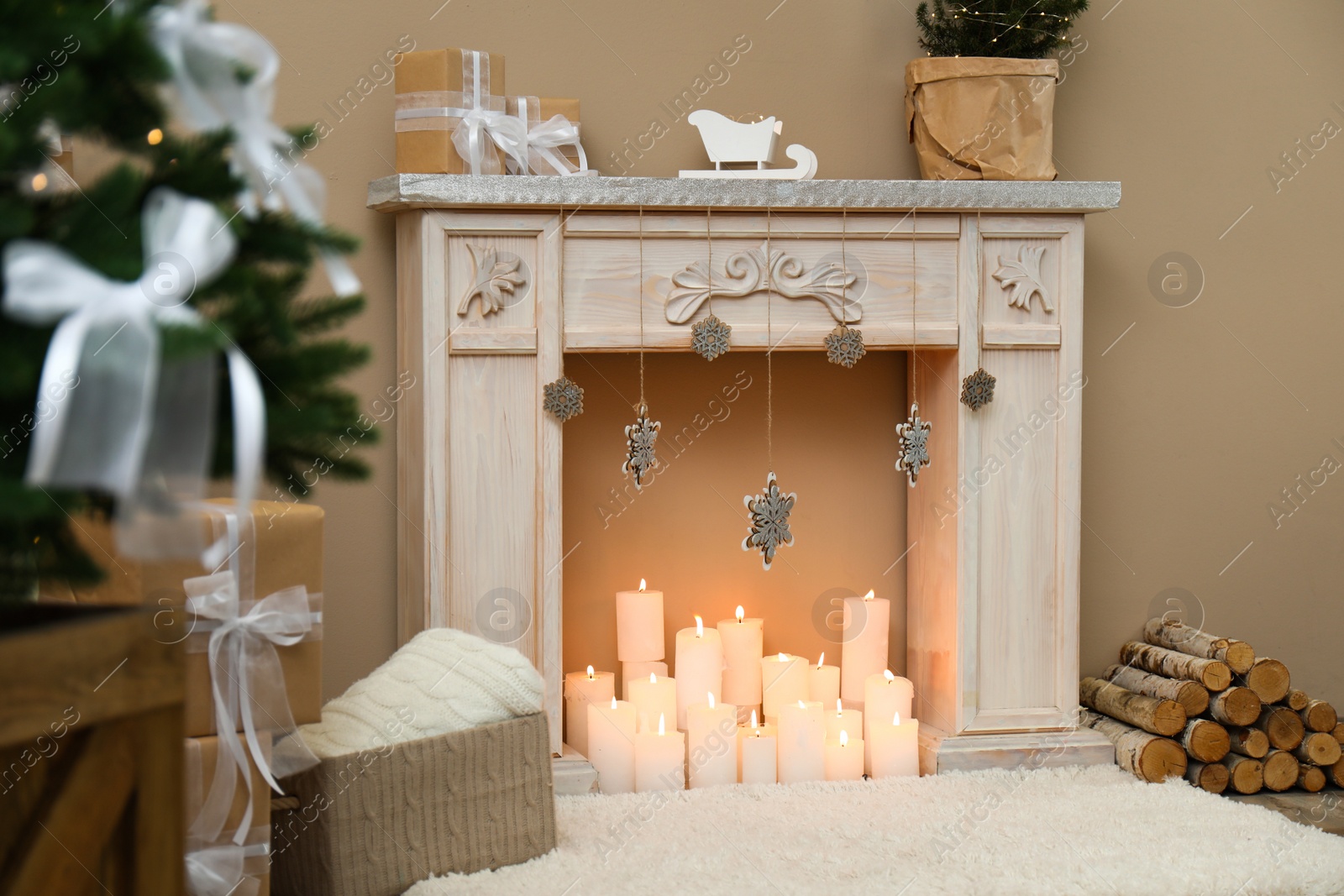 Photo of Fireplace with burning candles in festive room interior. Christmas celebration