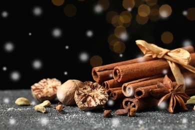 Image of Different spices on grey table, closeup. Cinnamon, anise, cloves, cardamom, nutmegs