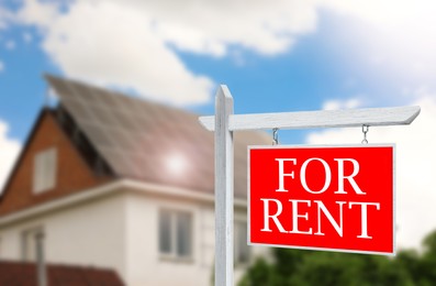 Sign with phrase FOR RENT and blurred view of beautiful house