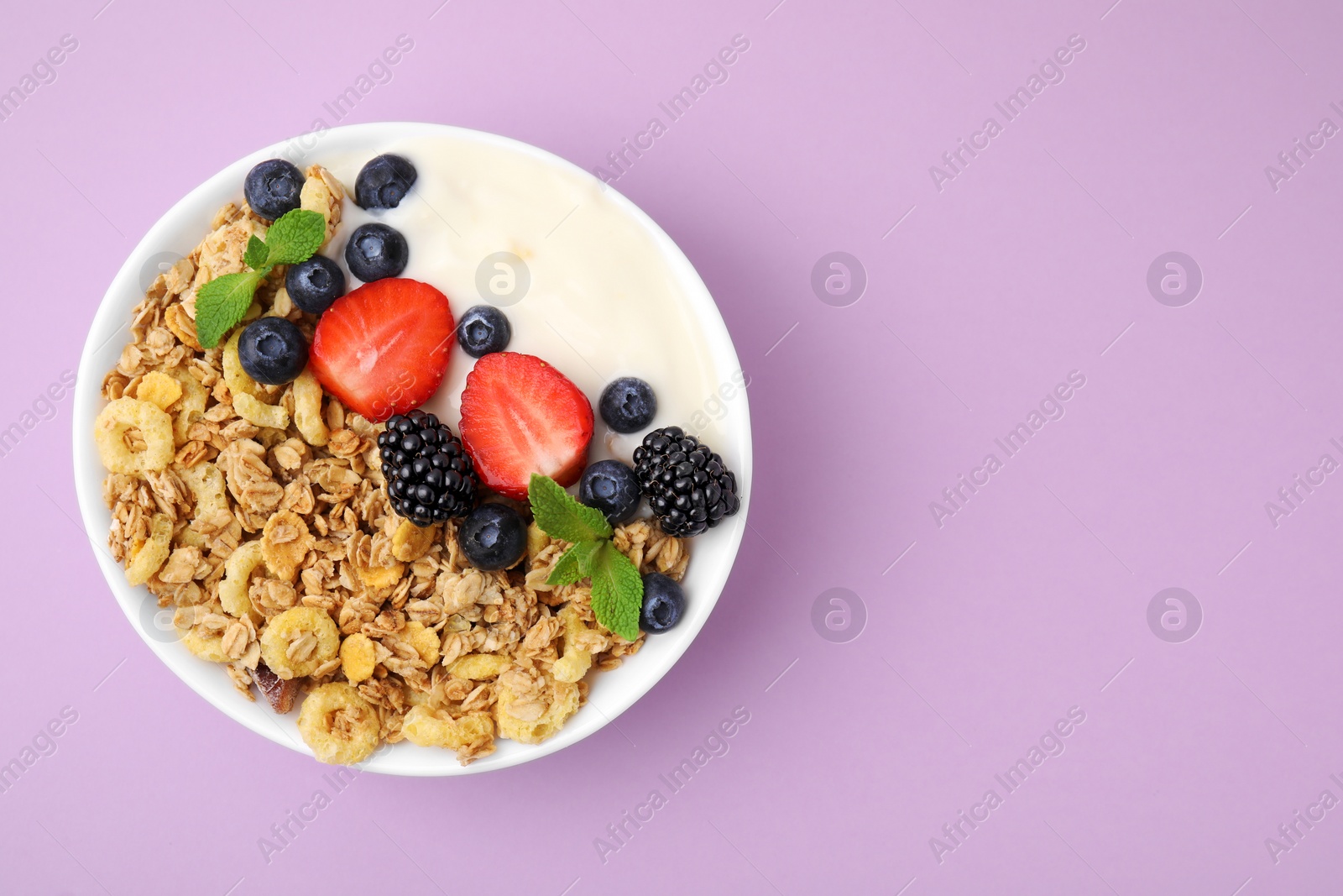 Photo of Tasty oatmeal, yogurt and fresh berries in bowl on lilac background, top view with space for text. Healthy breakfast