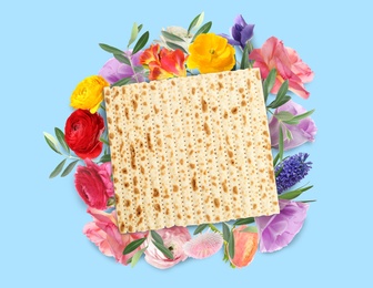 Image of Tasty matzo and flowers on blue background, flat lay. Passover (Pesach) celebration