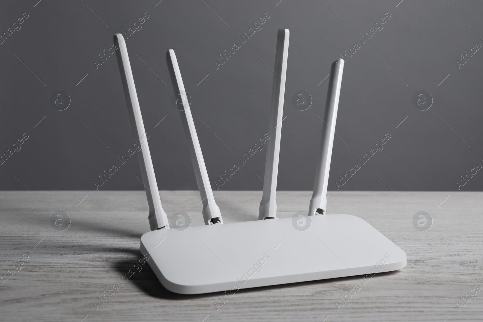 Photo of New stylish Wi-Fi router on white wooden table