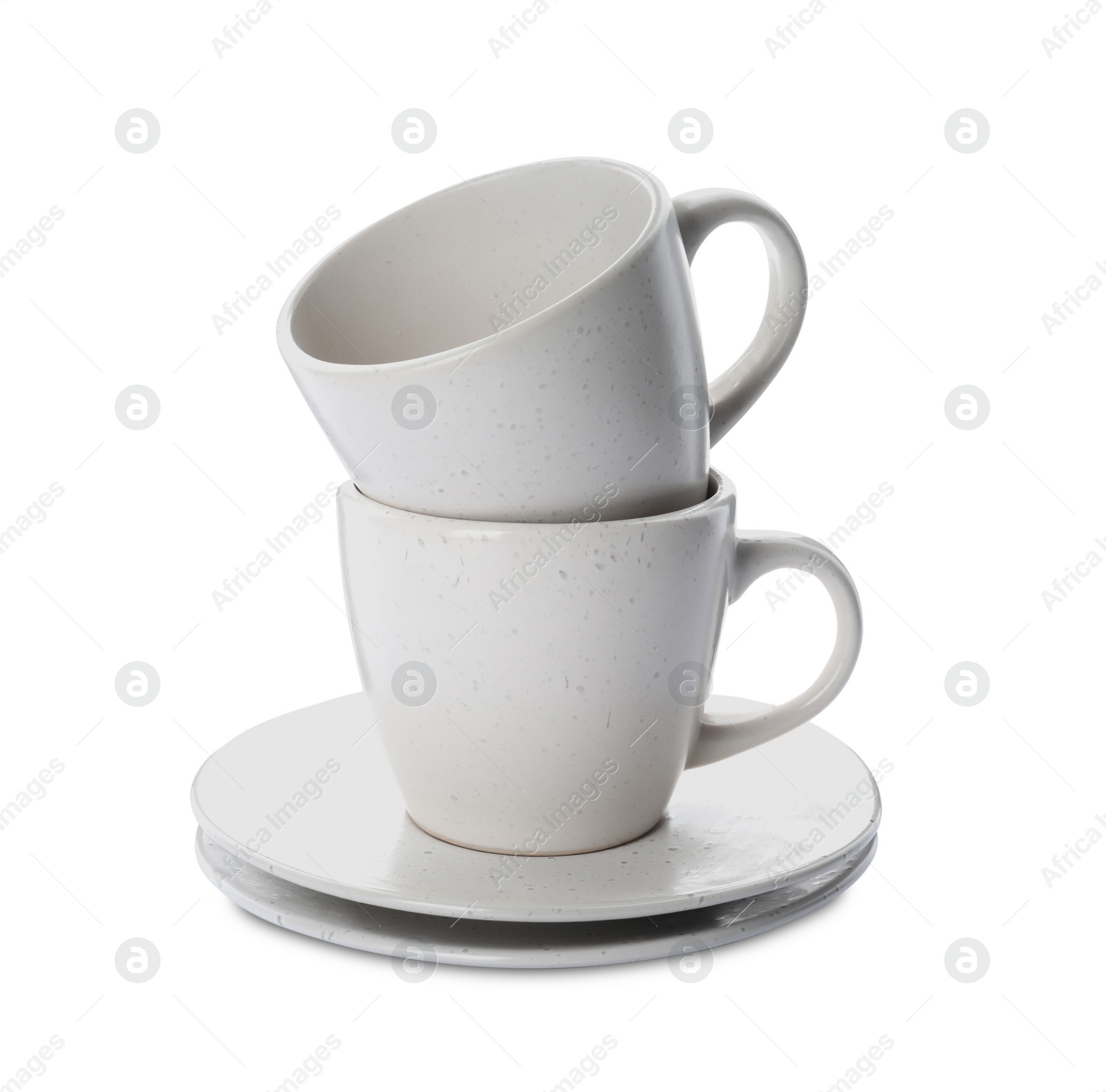 Photo of New clean ceramic cups and saucers on white background