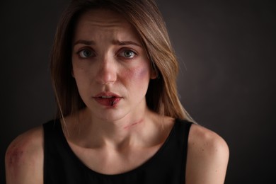 Photo of Woman with facial injuries on black background. Domestic violence victim