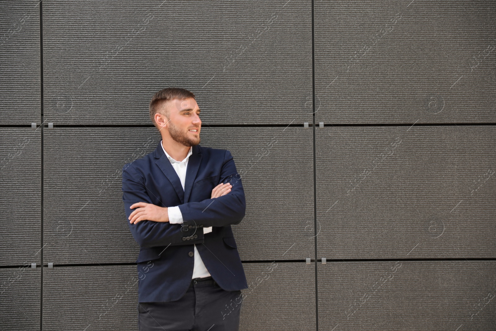 Photo of Portrait of handsome young man leaning to wall outdoors, space for text