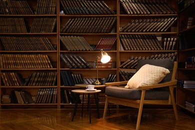 Photo of Cozy home library interior with comfortable armchair and collectionvintage books on shelves