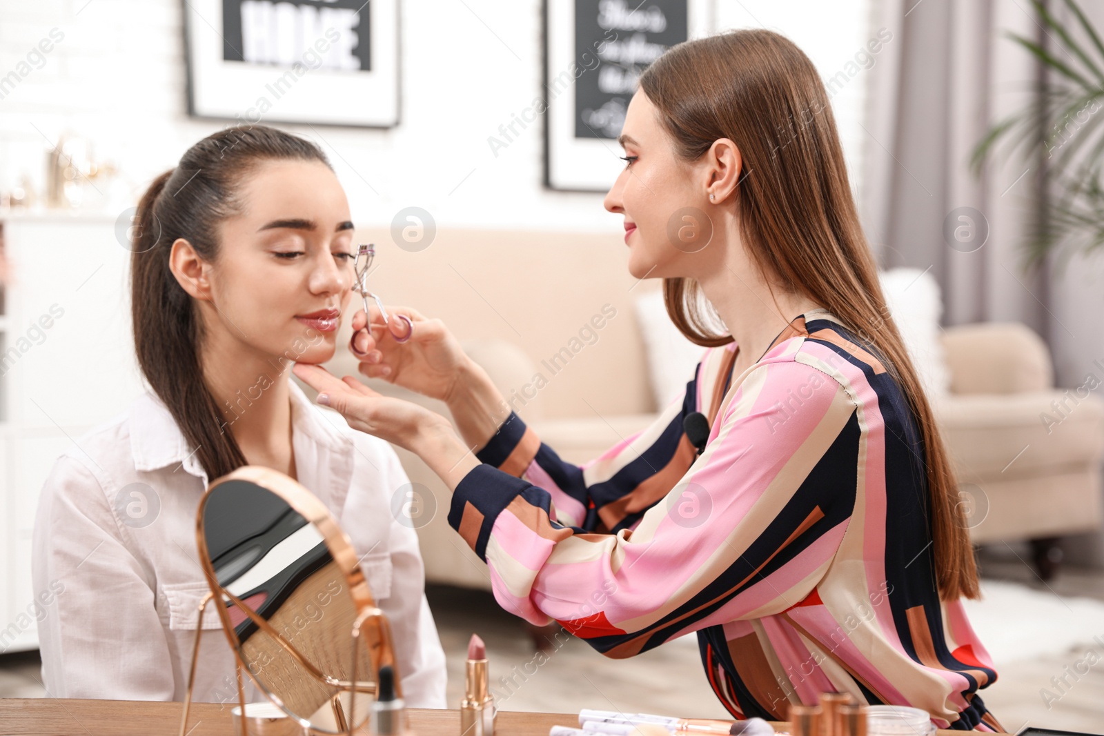 Photo of Beauty blogger doing model's makeup at home