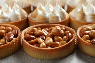 Many different tartlets on light grey table, closeup. Tasty dessert