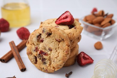 Photo of Cookies with freeze dried fruits, cinnamon, honey and nuts on white table, closeup