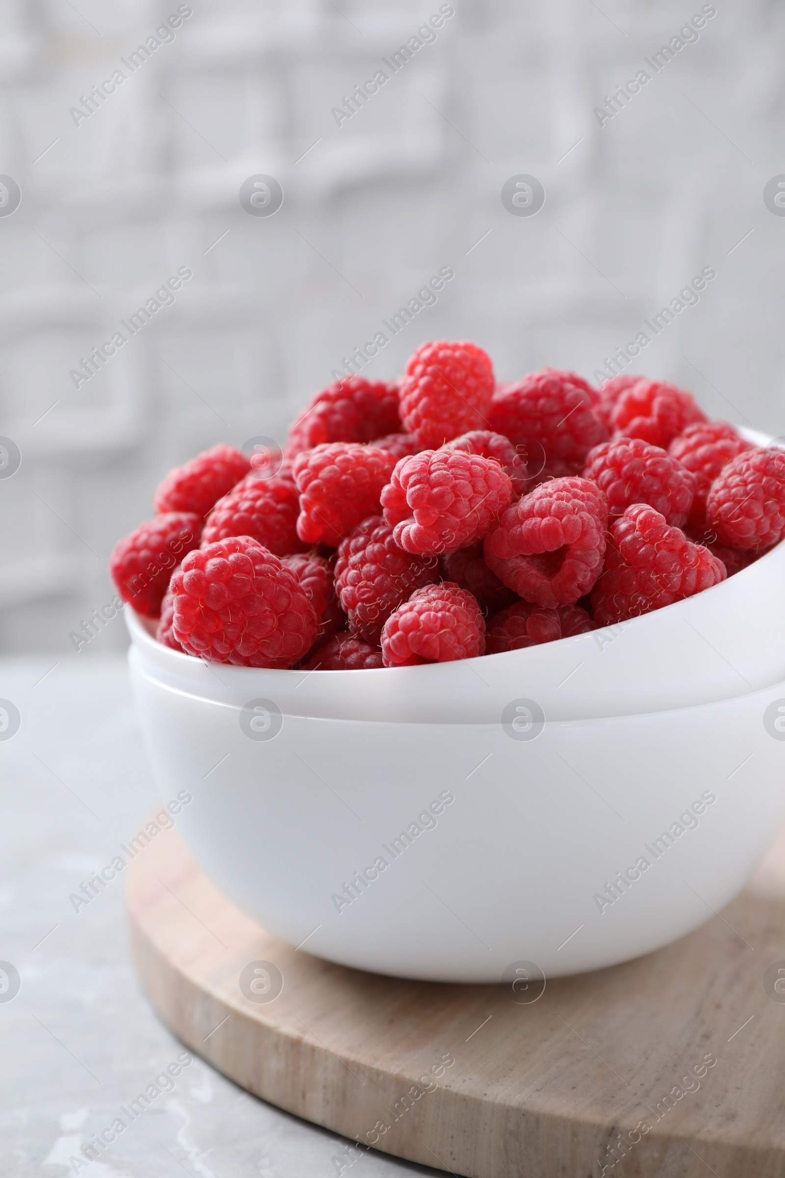 Photo of Delicious fresh ripe raspberries on grey table