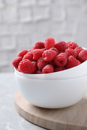 Photo of Delicious fresh ripe raspberries on grey table