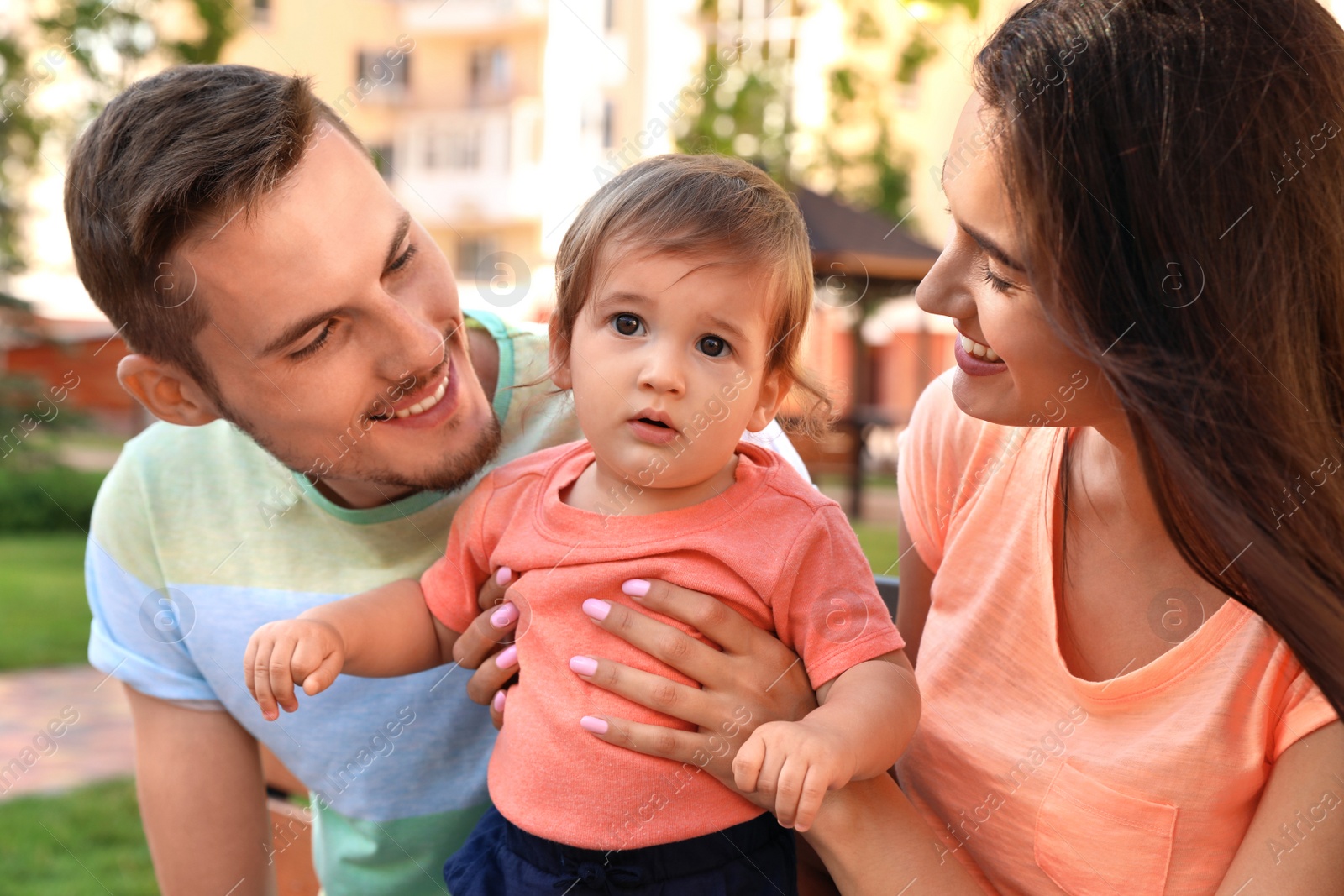 Photo of Happy family with adorable little baby outdoors