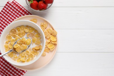 Photo of Bowl of tasty corn flakes and strawberries served on white wooden table, flat lay. Space for text
