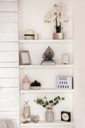 Photo of Wall shelves with beautiful decor elements indoors. Interior design