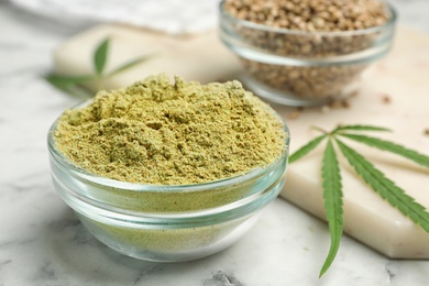 Bowl of hemp protein powder on marble table, closeup