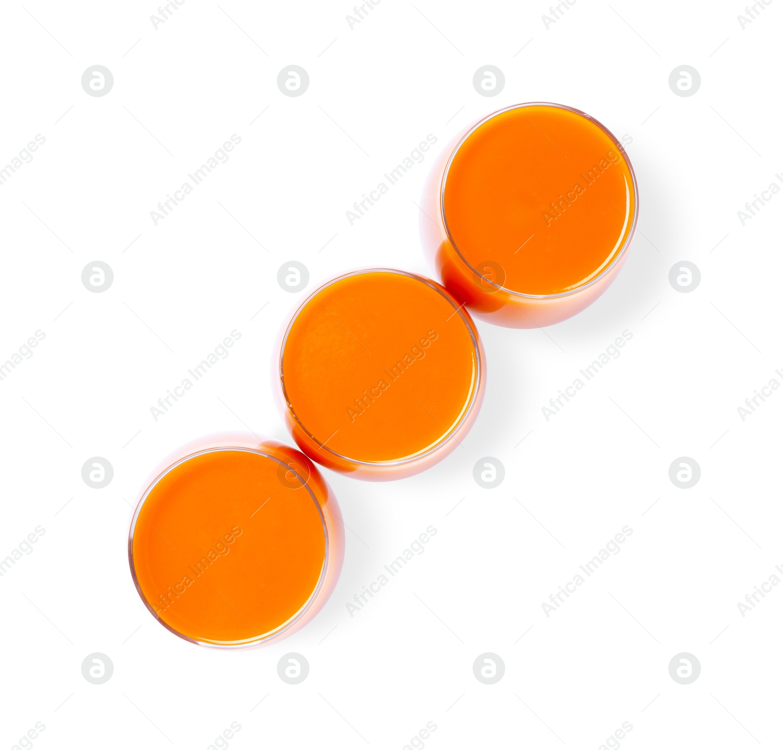 Photo of Three glasses of fresh carrot juice on white background, top view