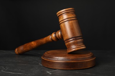 Wooden gavel on dark textured table, closeup