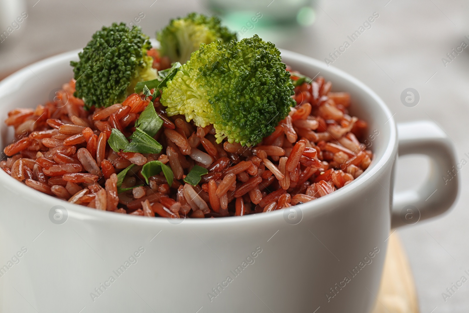 Photo of Tasty brown rice with broccoli on table, closeup