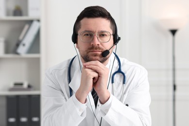 Photo of Doctor in headset having online consultation in clinic