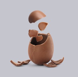 Image of Exploded milk chocolate egg on grey background
