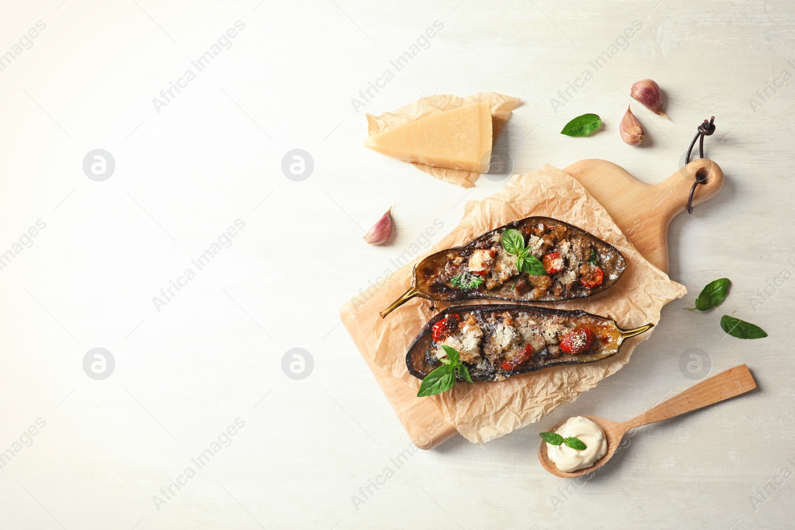 Photo of Flat lay composition with stuffed eggplants and space for text on light table