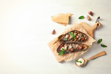 Photo of Flat lay composition with stuffed eggplants and space for text on light table