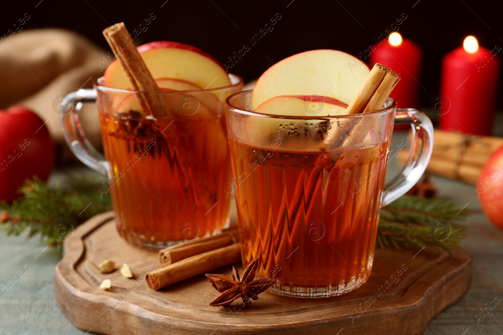 Photo of Aromatic hot mulled cider on wooden board