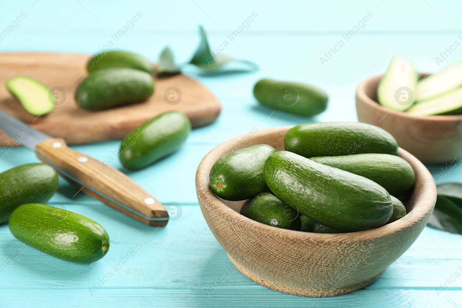 Photo of Fresh seedless avocados on turquoise wooden table