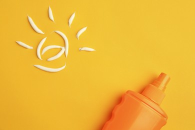 Photo of Drawing of sun and bottle with sunscreen on orange background, top view. Skin protection