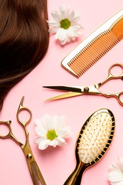 Flat lay composition with different hairdresser tools and flowers on pink background